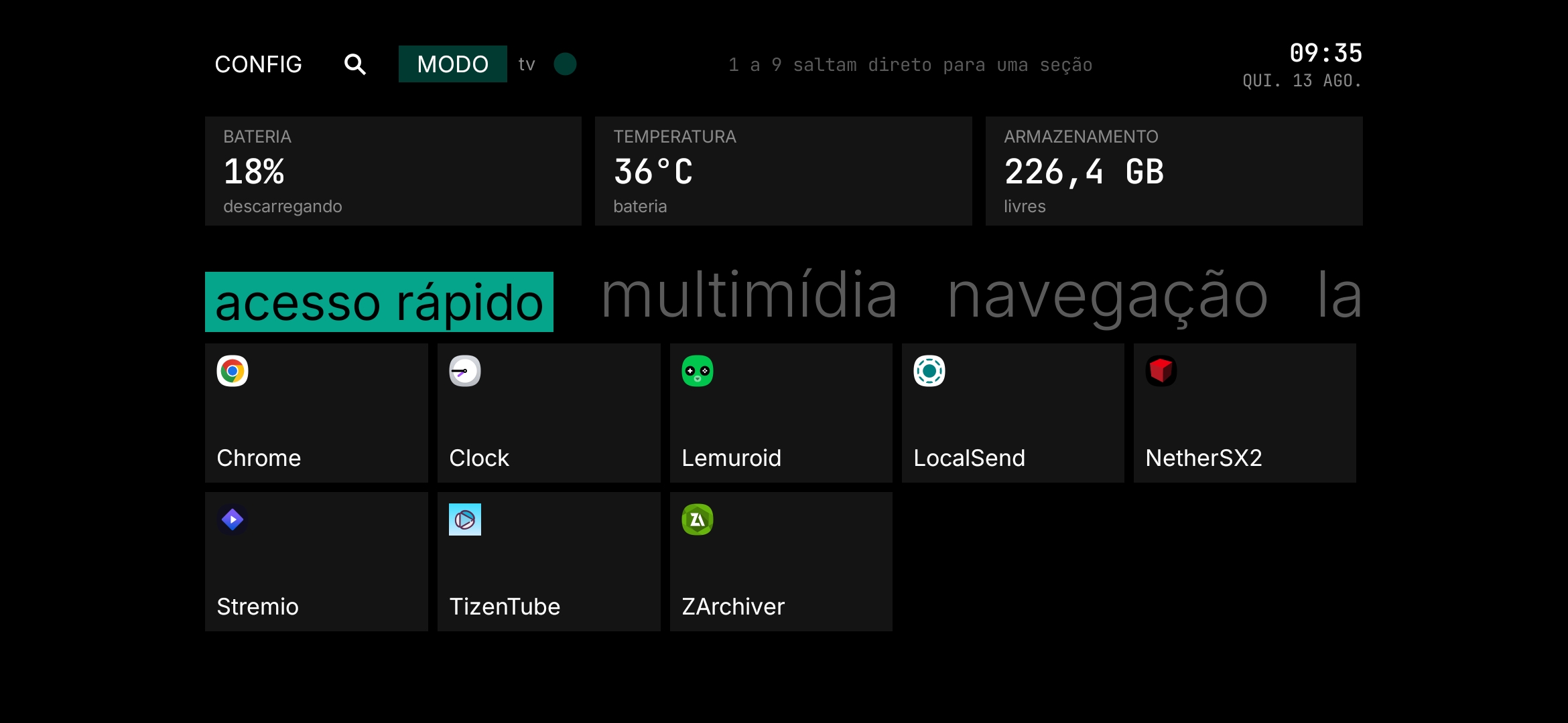 A Revya TV na tela grande: barra superior com config, busca e alternância de modo; cartões de bateria, temperatura e armazenamento; e as seções Emuladores, Ferramentas e Outros com os apps em grade.